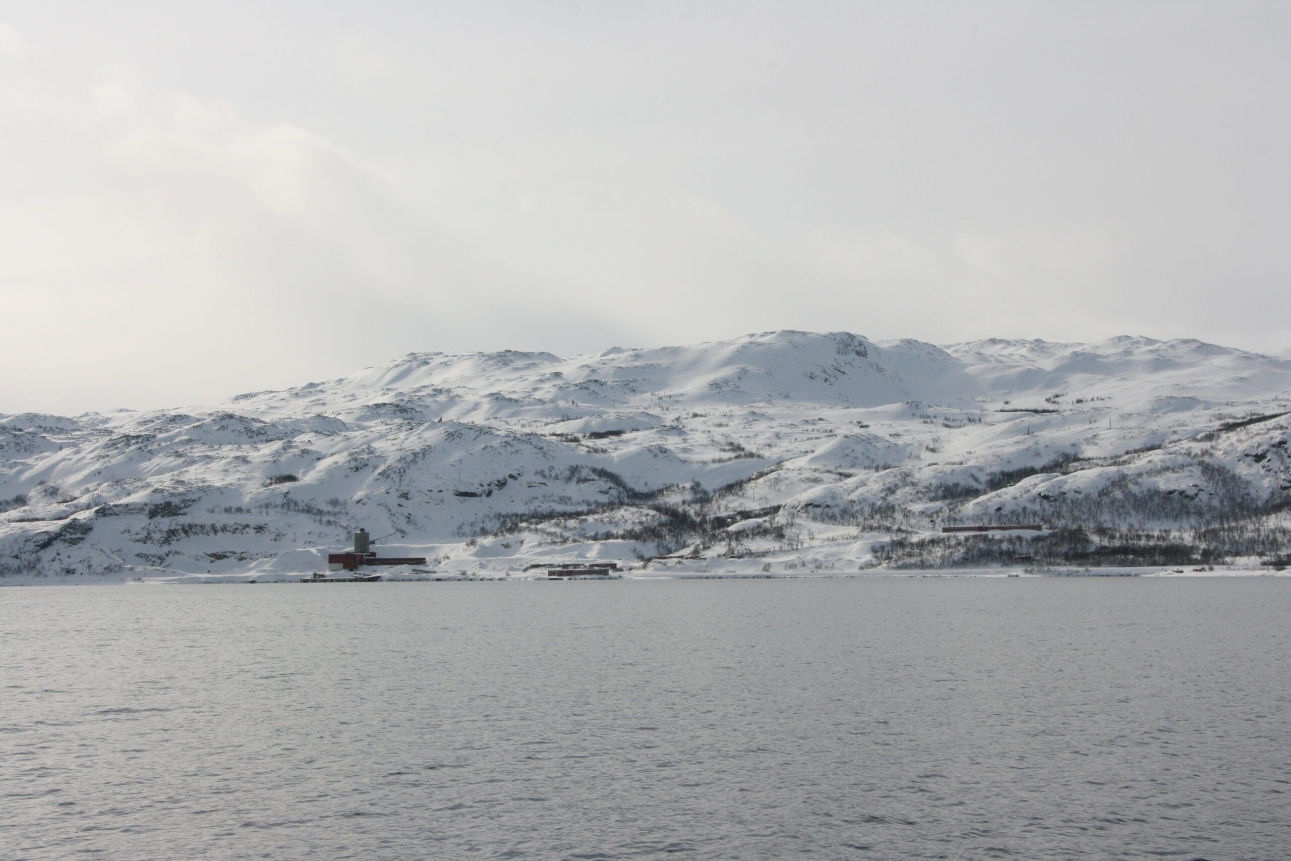 Foto av snødekt landskap tatt fra båt