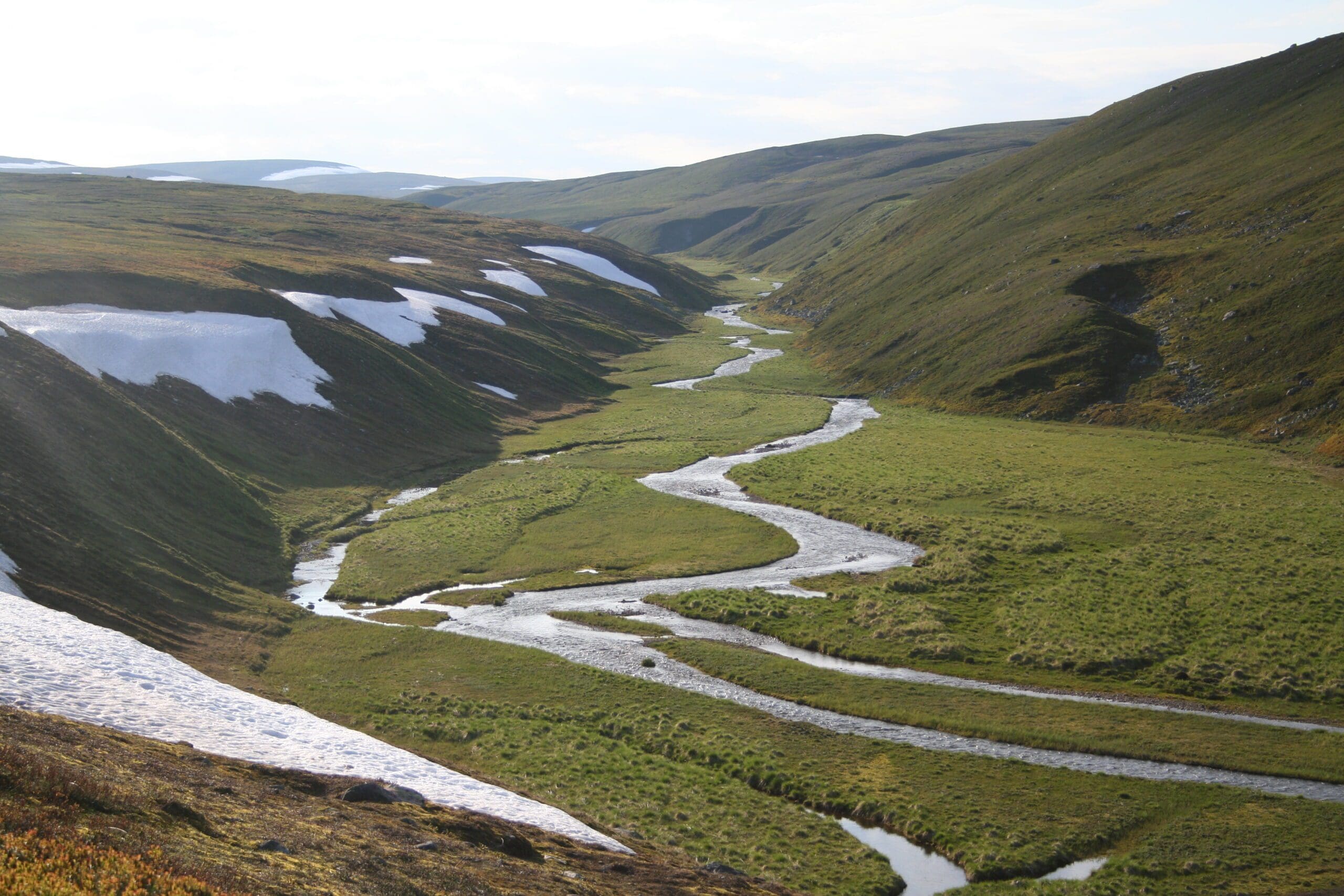 Foto av landskap med en elv som renner gjennom en dal