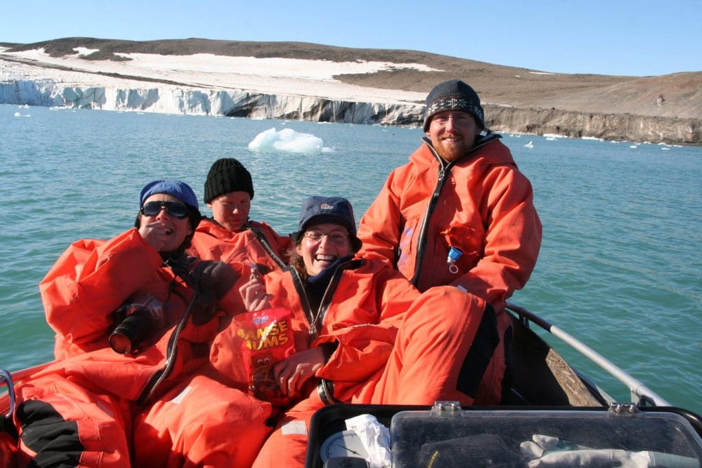 Foto av forskere som sitter sammen i en liten båt